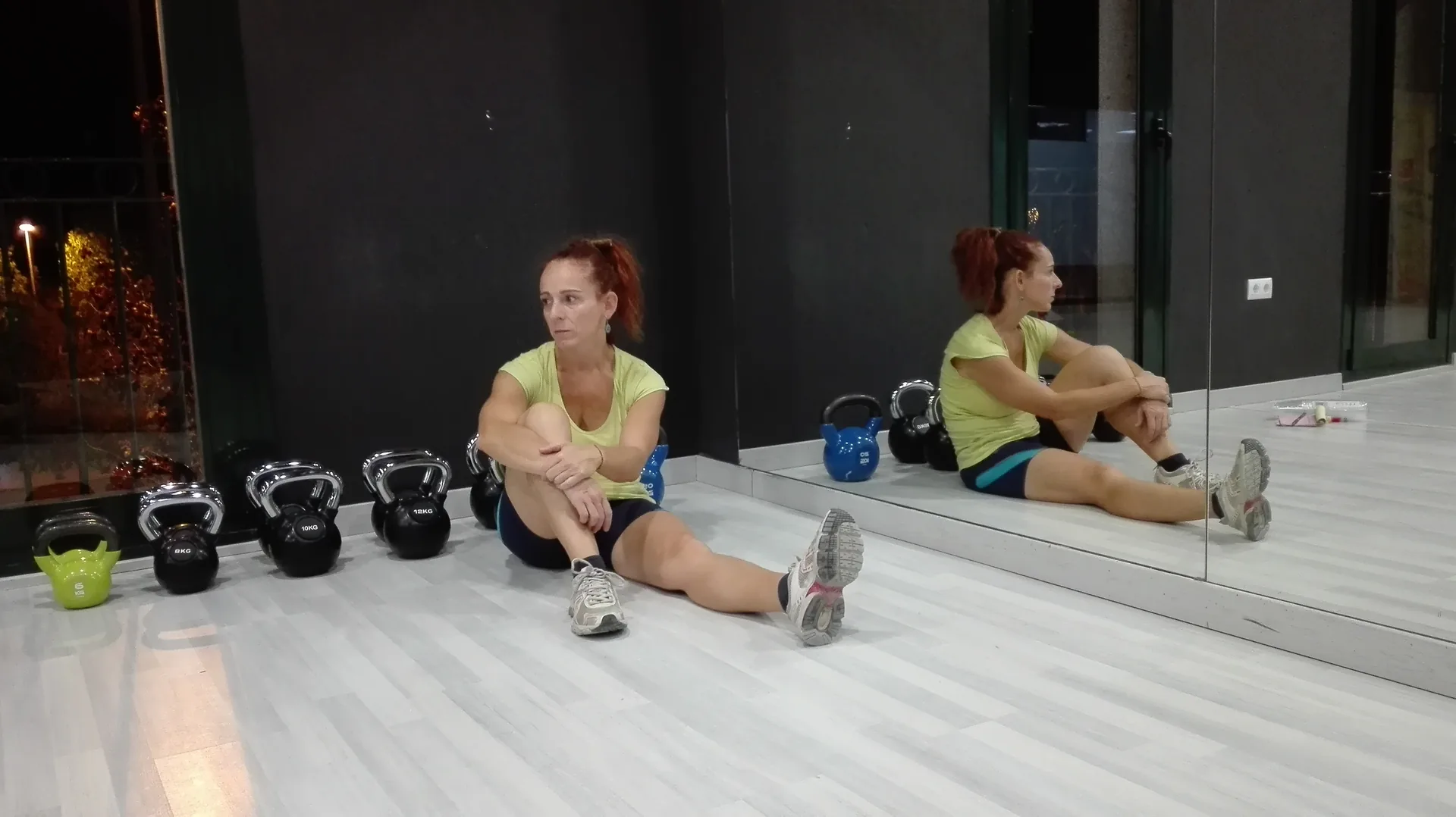 Alicia sentada junto a unas kettlebells en el primer local de CEFYD, la noche antes de abrir